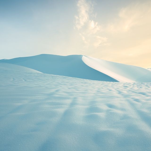 snow covered desert sand dunes at sunset