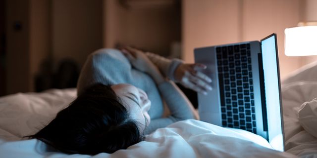 a woman using her laptop in bed