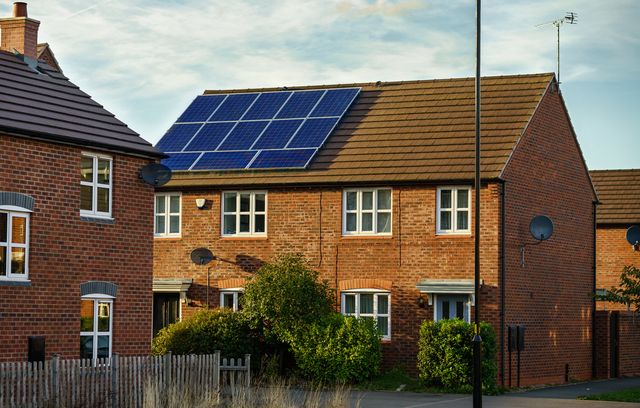 solar photovoltaic panels mounted on a tiled new familiy houses roof, england