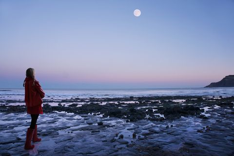solitary woman in red on a moonlit beach
