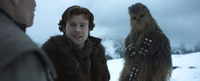 solo a star wars story alden ehrenreich as han solo, standing in the snow with chewbacca joonas suotamo