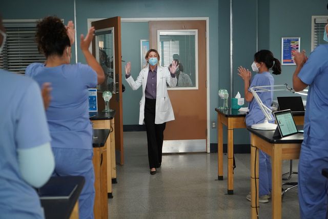 ellen pompeo fotografata mentre entra in una stanza tra gli applausi degli infermieri in una scena della stagione 17 di grey's anatomy