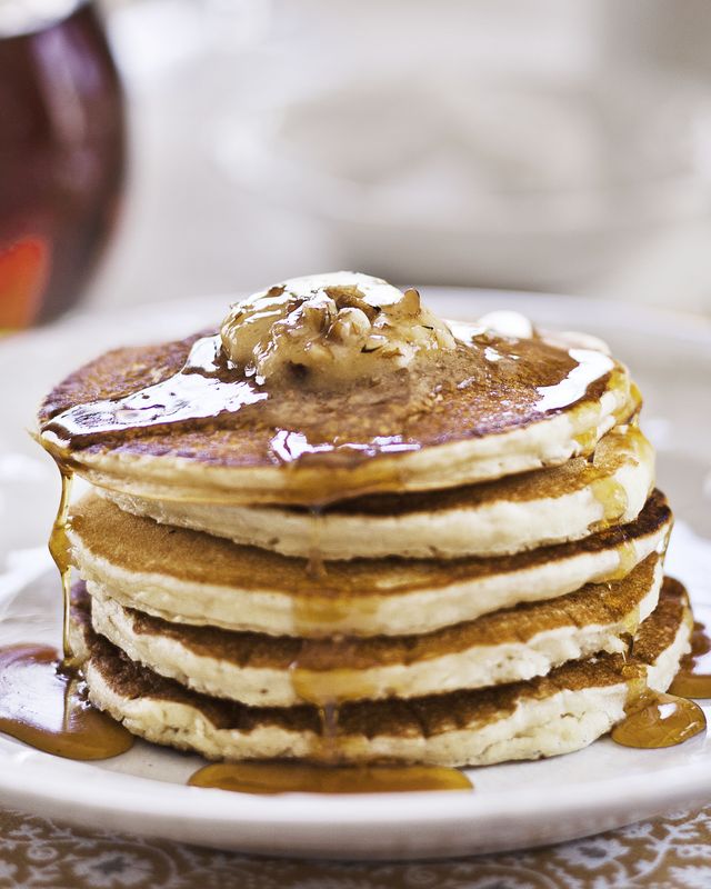 a stack of five sour cream pancakes with maple pecan butter on top