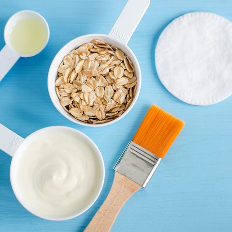 Sour cream (or greek yogurt), rolled oats and olive oil in the small plastic scoops - ingredients for preparing diy masks, scrubs and moisturizers. Homemade cosmetics recipe. Top view, copy space. greek yogurt rolled oats and olive oil face mask ingredients
