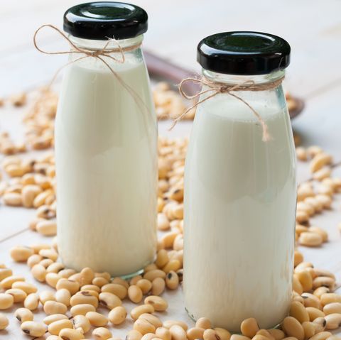 Soy milk in  glass bottle with soy pods