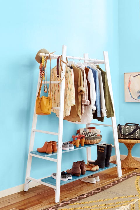 white ladder clothing rack against blue wall white ladder clothing rack against blue wall