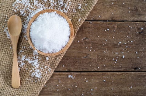 sale marino bianco in una ciotola di legno con un cucchiaio di legno