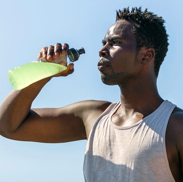 athlete drinking sports drink in water bottle