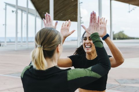 sporty friends giving a high five after workout together