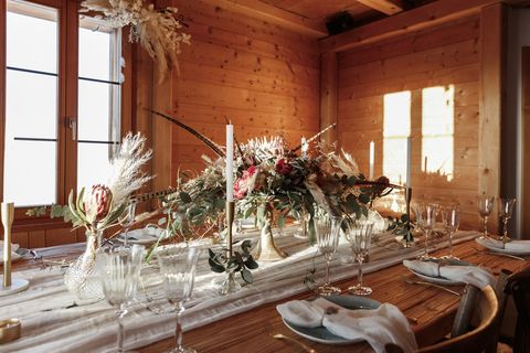 decoration of a wedding dinner in an alpine hut, engadin st moritz with flowers and candles and wood