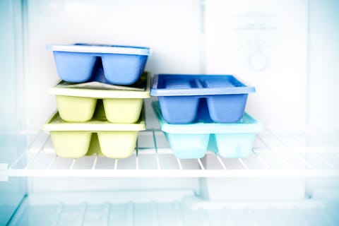 Stacked ice cube trays in a freezer