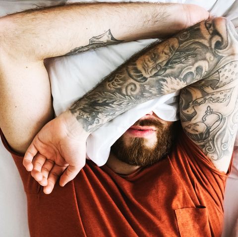 Man in bed covering face