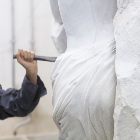 Stonemason using chisel and mallet to create sculpture