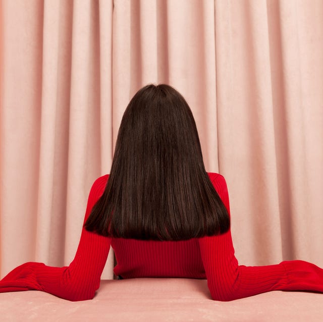 Red, Black, Pink, Curtain, Long hair, Interior design, Shoulder, Sitting, Tights, Window treatment, 