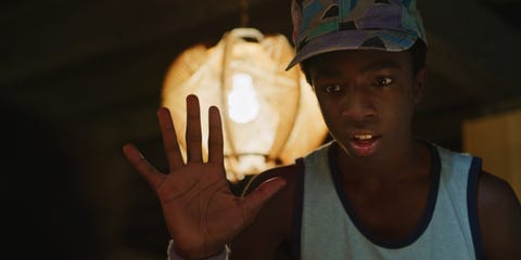 caleb mclaughlin as lucas, holding his right hand up to the camera, in a photo from stranger things season 3