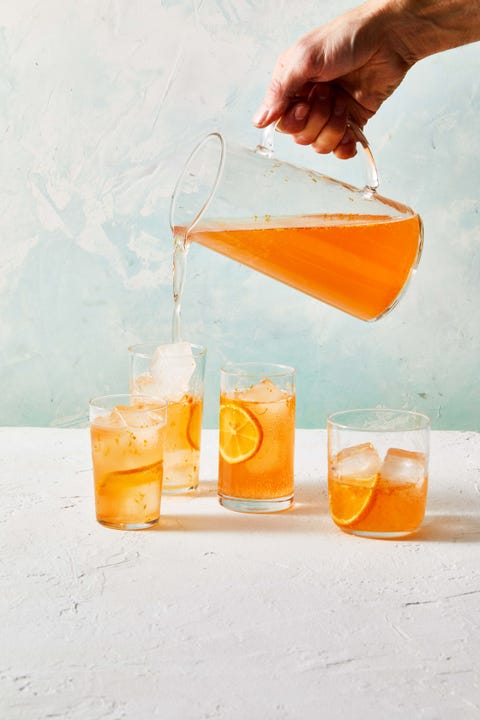 orange strawberry meyer lemon spritz being poured into cocktail glasses