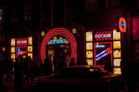 street scene at night with colorful neon sex signs