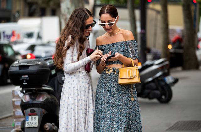 paris, france   july 01 géraldine boublil is seen wearing grey off shoulder dress, yellow bag, erika boldrin on their smartphone outside schiaparelli during paris fashion week   haute couture fallwinter 20192020 on july 01, 2019 in paris, france photo by christian vieriggetty images