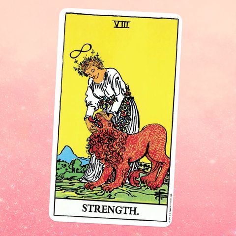 strength tarot card a woman in a white dress strokes a lion