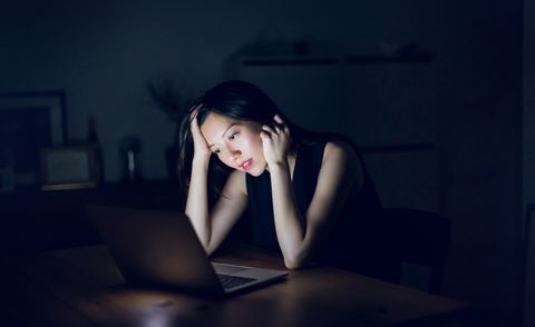stressed and frustrated businesswoman working on laptop till late at work