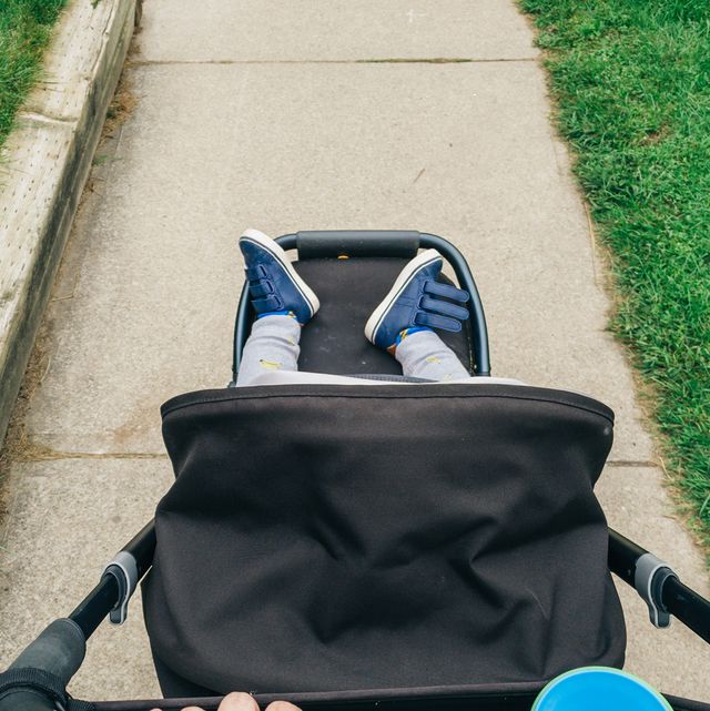 person pushing stroller with organizer hanging off handle