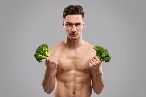 Strong man holding fresh broccoli