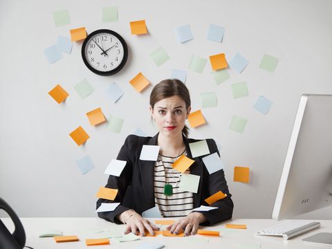 studio shot of young woman working in office covered with adhesive notes
