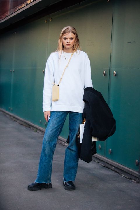milan, italy   february 26 model evie harris wears a white sweater, blue jeans, black boots, and small rectangular cross body jil sander bag after the philosophy di lorenza serafini show at palazzo del ghiaccio during the milan fashion week fallwinter 20222023 on february 26, 2022 in milan, italy photo by melodie jenggetty images
