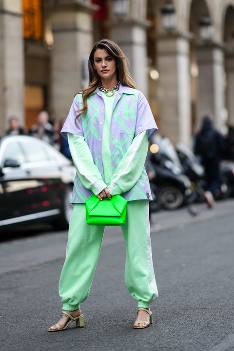 paris, france   march 01 clara berry wears silver earrings, a large silver and gold buckle necklace, a pale green sweater, matching pale green sport pants, a pale purple and pale green print pattern short shirt, a neon green shiny leather handbag, green khaki shiny leather strappy block heels sandals, outside koche, during paris fashion week   womenswear fw 2022 2023, on march 01, 2022 in paris, france photo by edward berthelotgetty images