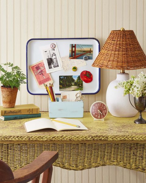 enamelware platter turned into a memo board for a summer crafts project hangs above a yellow wicker desk