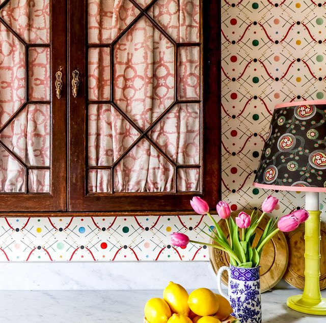 counter with colorful wallpaper, cabinets, and flowers