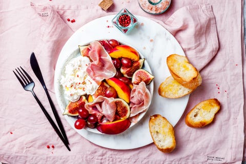 Summer fruit salad with burrata, peaches, figs, grapes, jamon or prosciutto. Top view, overhead summer fruit salad with burrata, peaches, figs, grapes, jamon or prosciutto top view, overhead