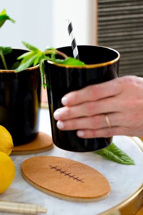 super bowl party ideas, football coasters with hand holding plant