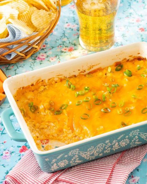 buffalo chicken dip in blue baking dish with beer and chips