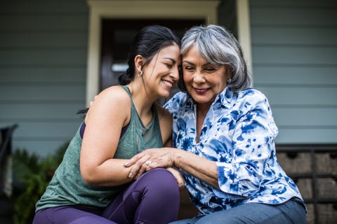 senior woman and adult daughter laughing on porch