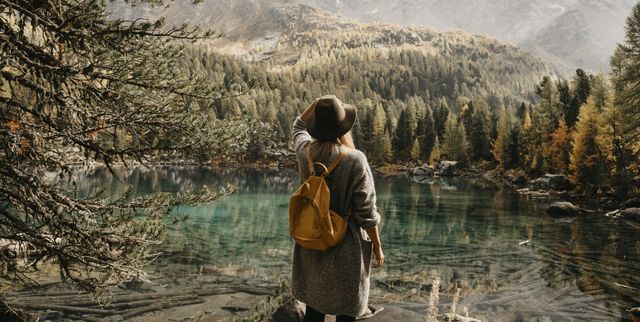 Switzerland, Engadin, woman on a hiking trip standing at lakeside in mountainscape
