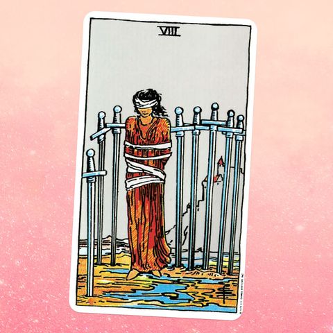 the Eight of Swords tarot card, showing a person in a long robe, bound and blindfolded, surrounded by eight swords