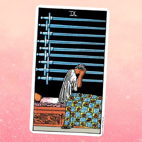 the tarot card the nine of swords a man is sitting in bed with his face in his hands, and nine swords hang on the wall next to him