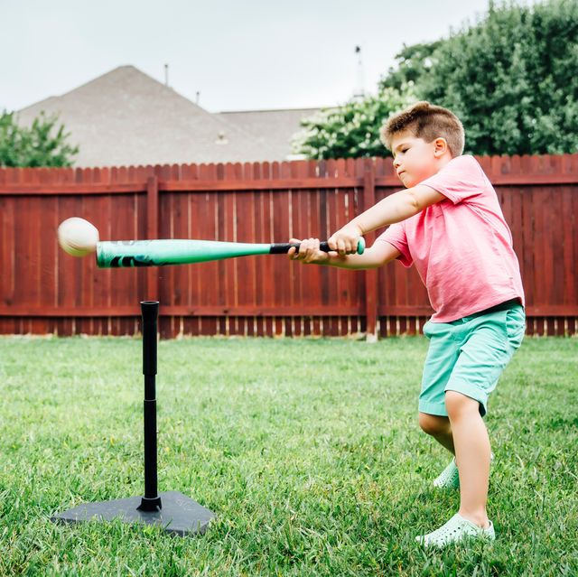 boy hitting baseball off tee