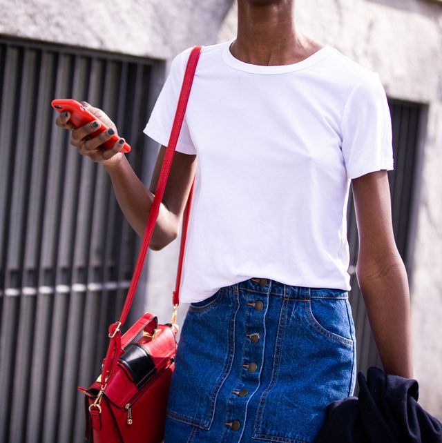 milan, italy   february 21 a model, wearing a white t shirt, checked hat, red bag and denim skirt, is seen outside emporio armani show, during milan fashion week fallwinter 2020 2021 on february 21, 2020 in milan, italy photo by claudio laveniagetty images