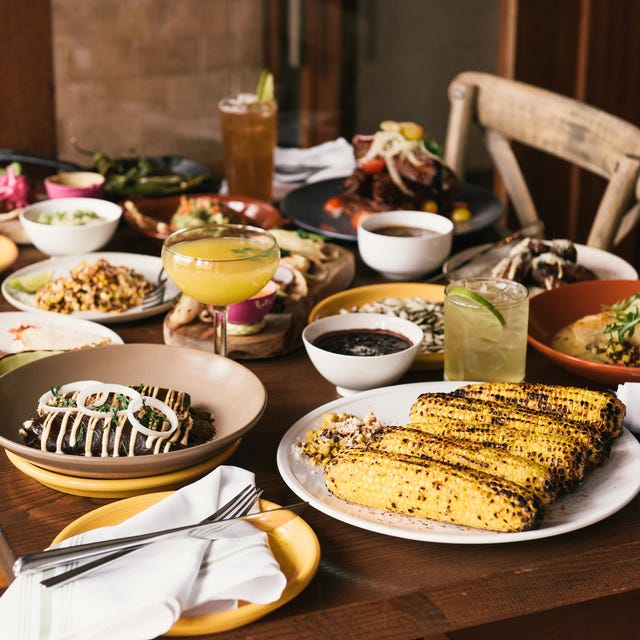 a table full of traditional mexican food, enchiladas, mole, tortillas