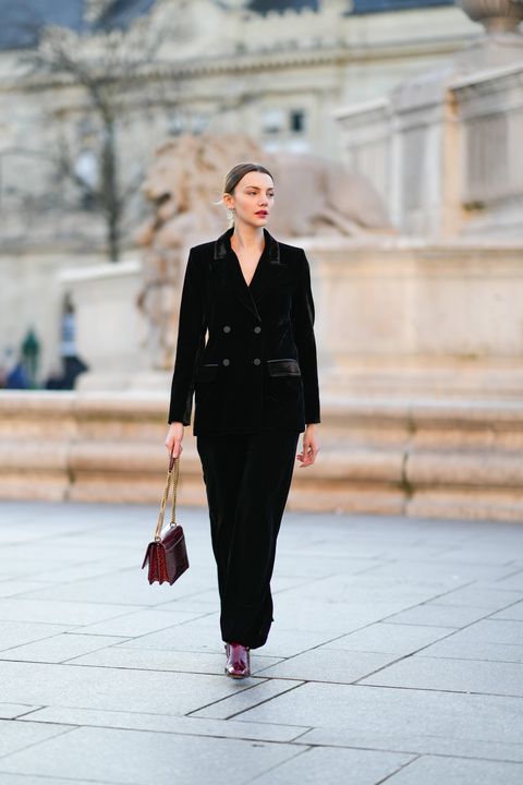 paris, france   december 18 olesya senchenko wears gold and pearls cc logo earrings from chanel, a black velvet buttoned blazer jacket, matching black velvet flared pants, a burgundy  red shiny leather crocodile print pattern with gold ysl buckle sunset handbag from yves saint laurent, a gold ring, burgundy shiny leather block heels ankle boot, during a street style fashion photo session, on december 18, 2021 in paris, france photo by edward berthelotgetty images