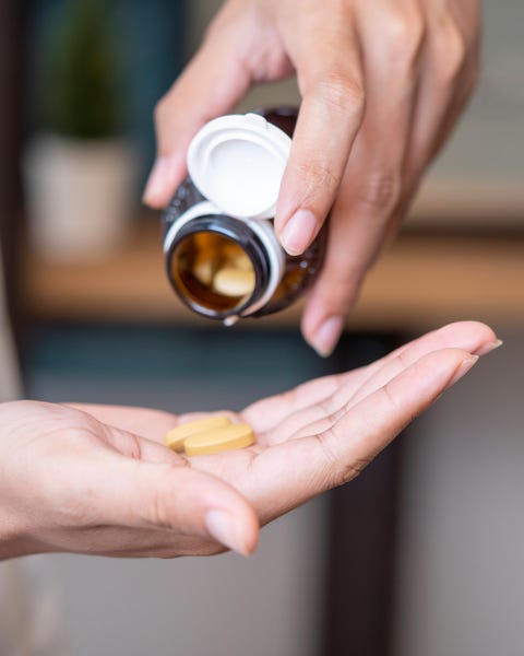 güneş yanığı için ek ev ilaçları alın vitamin ve takviyeleri alan kadın