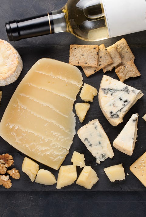 Tasting cheese dish on a dark stone plate. Food for wine and romantic date, cheese delicatessen on a black concrete background. Top view Tasting cheese dish on a dark stone plate. Food for wine and romantic date, cheese delicatessen on a black concrete background. Top view