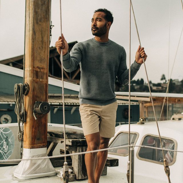 young man standing on sailboat in sweater and taylor stitch the morse linen short