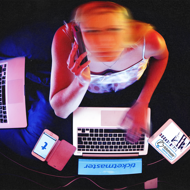 زن جوانی با چهره ای تار با دو لپ تاپ باز در تلاش برای خرید بلیط