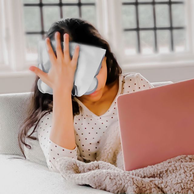 teen girl works on laptop while holding ice pack to head