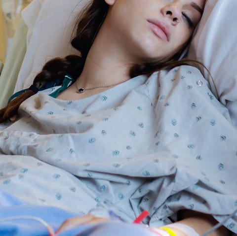 Teen mother labors in hospital bed during childbirth Teen mother labors in hospital bed during childbirth