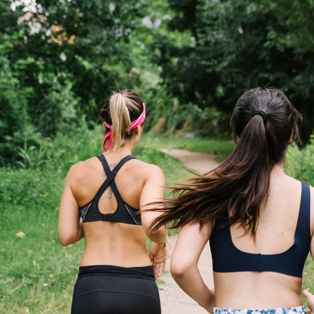 two teen girls running on trail in sports bras and leggings