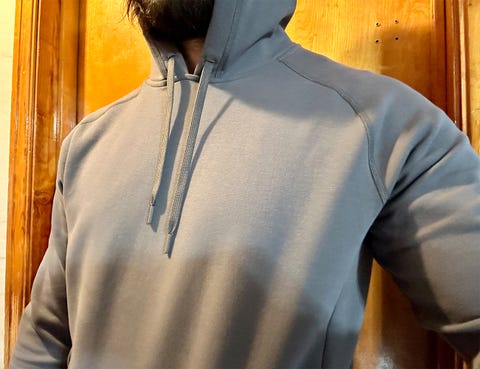 a man wearing a ten thousand midweight tech pullover hoodie